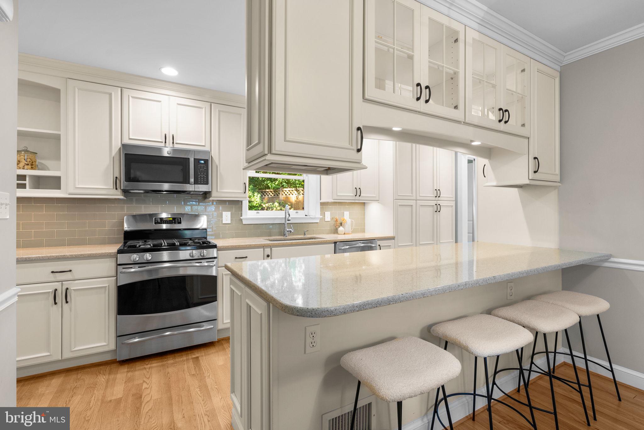 129 Lynnmoor Drive Silver Spring, MD 20901 - Photo 14 of 48 a kitchen with stainless steel appliances granite countertop a stove a white cabinets a a sink and a wooden floor