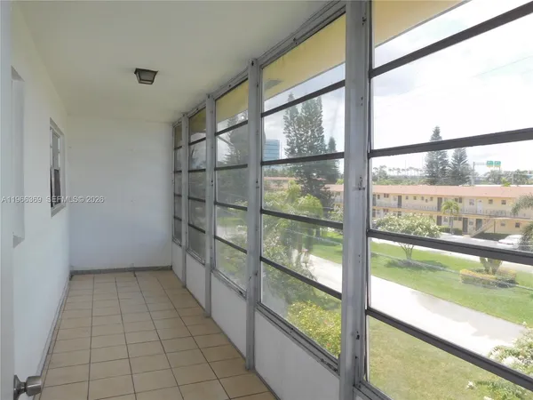 a view of empty room with window and wooden floor