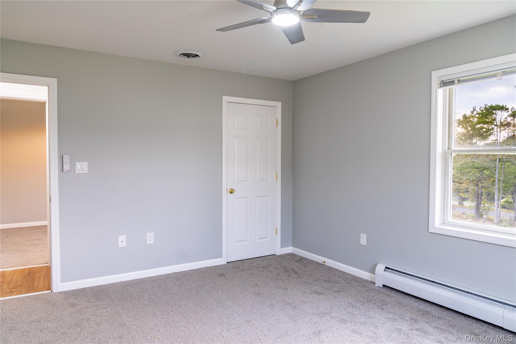 376 Wade Road Liberty, NY 12754 - Photo 12 of 26 Unfurnished bedroom featuring a baseboard heating unit, carpet, and a ceiling fan