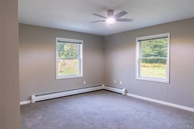 an empty room with a window and a fan