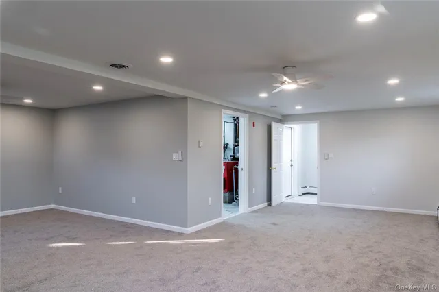 an empty room with an entryway and chandelier fan