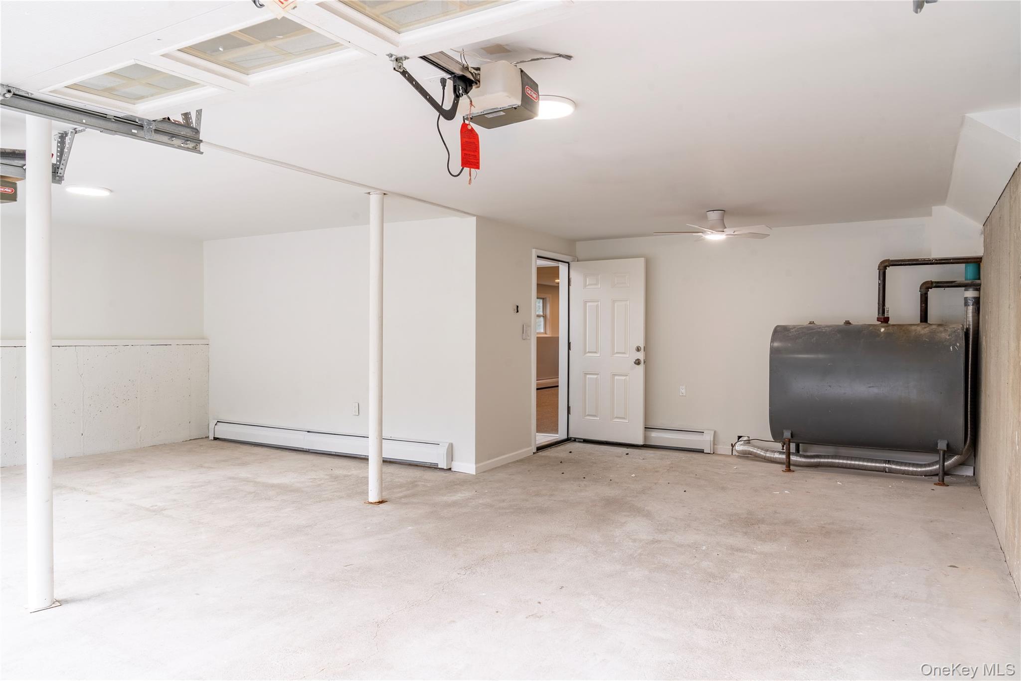 376 Wade Road Liberty, NY 12754 - Photo 22 of 26 Garage featuring oil tank, a baseboard radiator, and a garage door opener