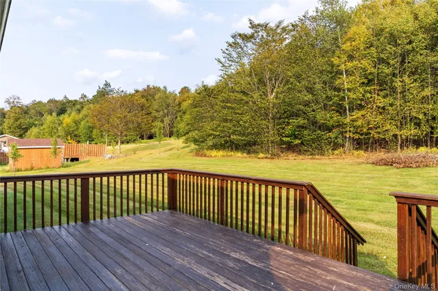 a view of deck with wooden floor and fence next to a yard