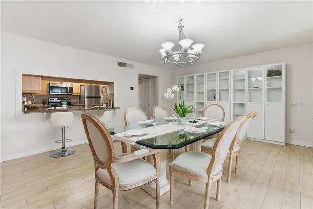 a dining room with furniture potted plants and wooden floor