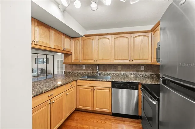 a kitchen with granite countertop a refrigerator stove and microwave