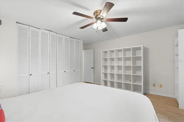 a bedroom with a large bed and a potted plant