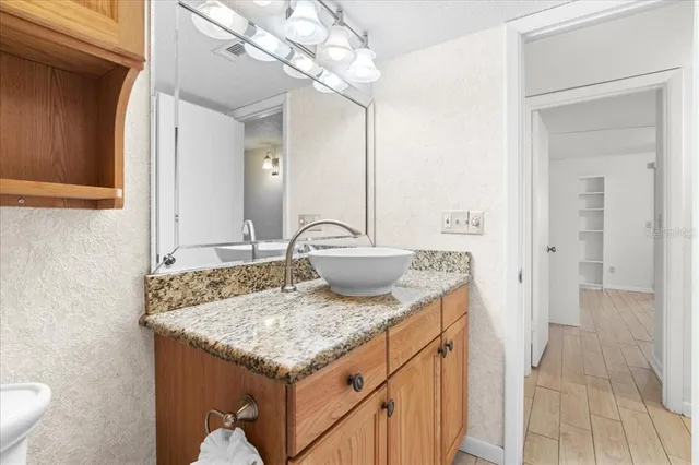 a bathroom with a granite countertop sink mirror vanity and toilet