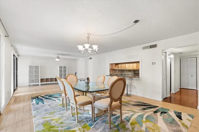 a view of a dining room with furniture a chandelier and wooden floor