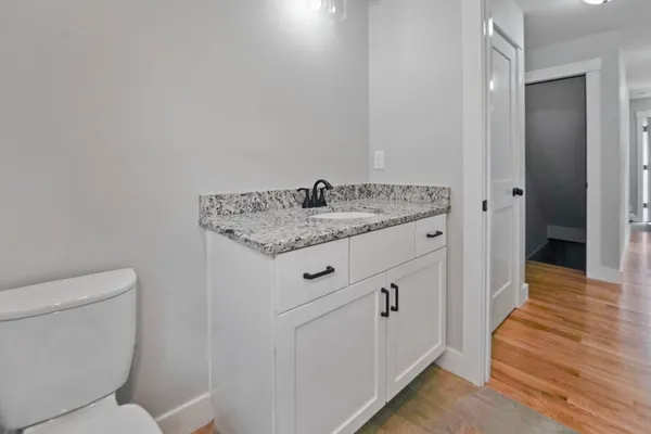 a bathroom with a granite countertop toilet and a sink