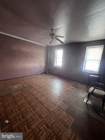 an empty room with windows and ceiling fan