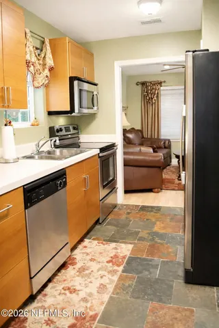 a kitchen with stainless steel appliances granite countertop a stove a sink and a refrigerator