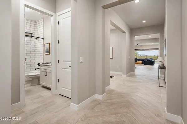 a view of a hallway with bathroom and a sink