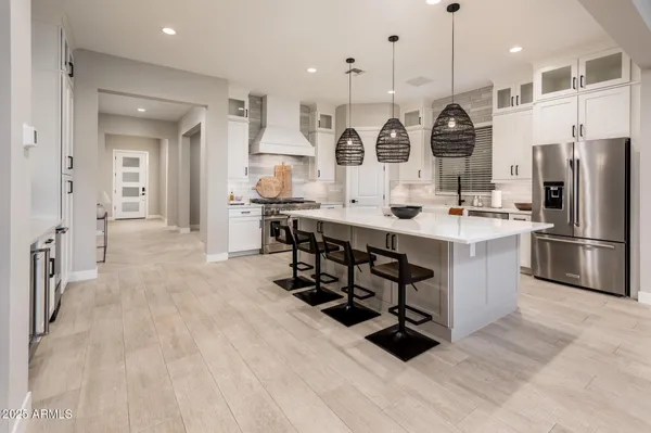 a kitchen with stainless steel appliances a sink a stove a refrigerator and cabinets