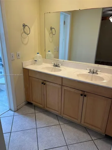 an empty room with wooden floor and a chandelier fan