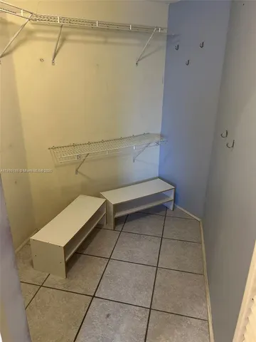 an empty room with wooden floor chandelier and windows