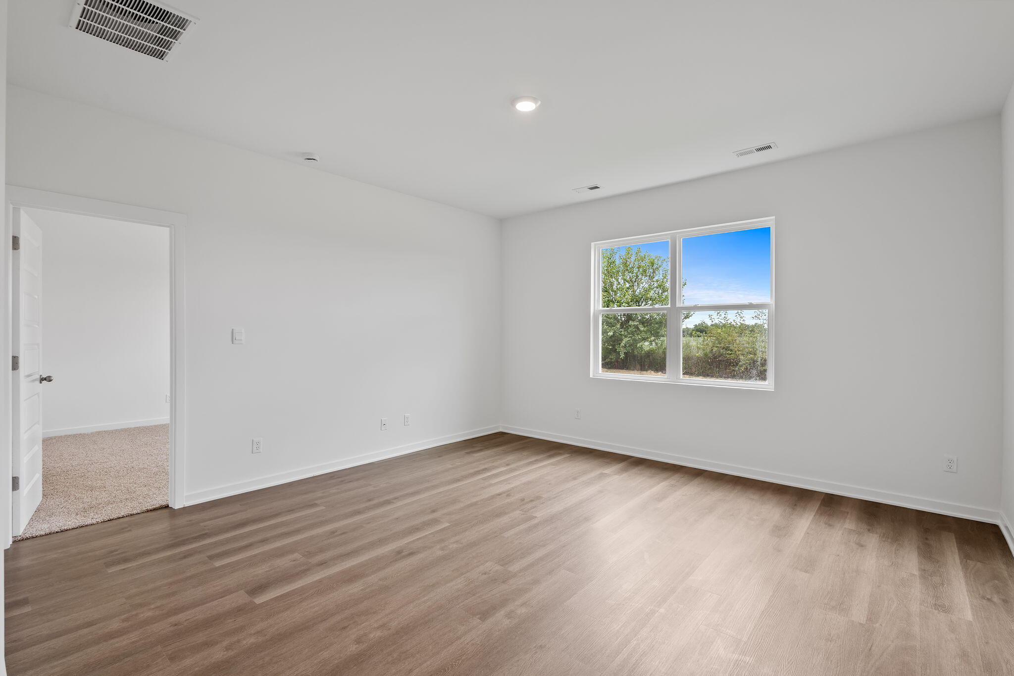 7293 West 107th Place Crown Point, IN 46307 - Photo 11 of 24 an empty room with wooden floor and windows
