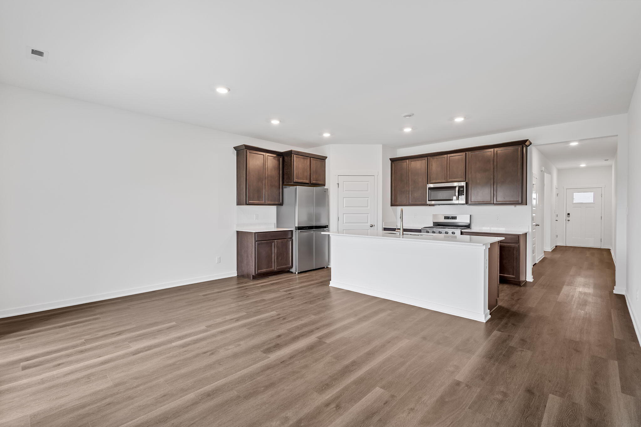 7293 West 107th Place Crown Point, IN 46307 - Photo 8 of 24 a view of kitchen with microwave a refrigerator and white cabinets with wooden floor