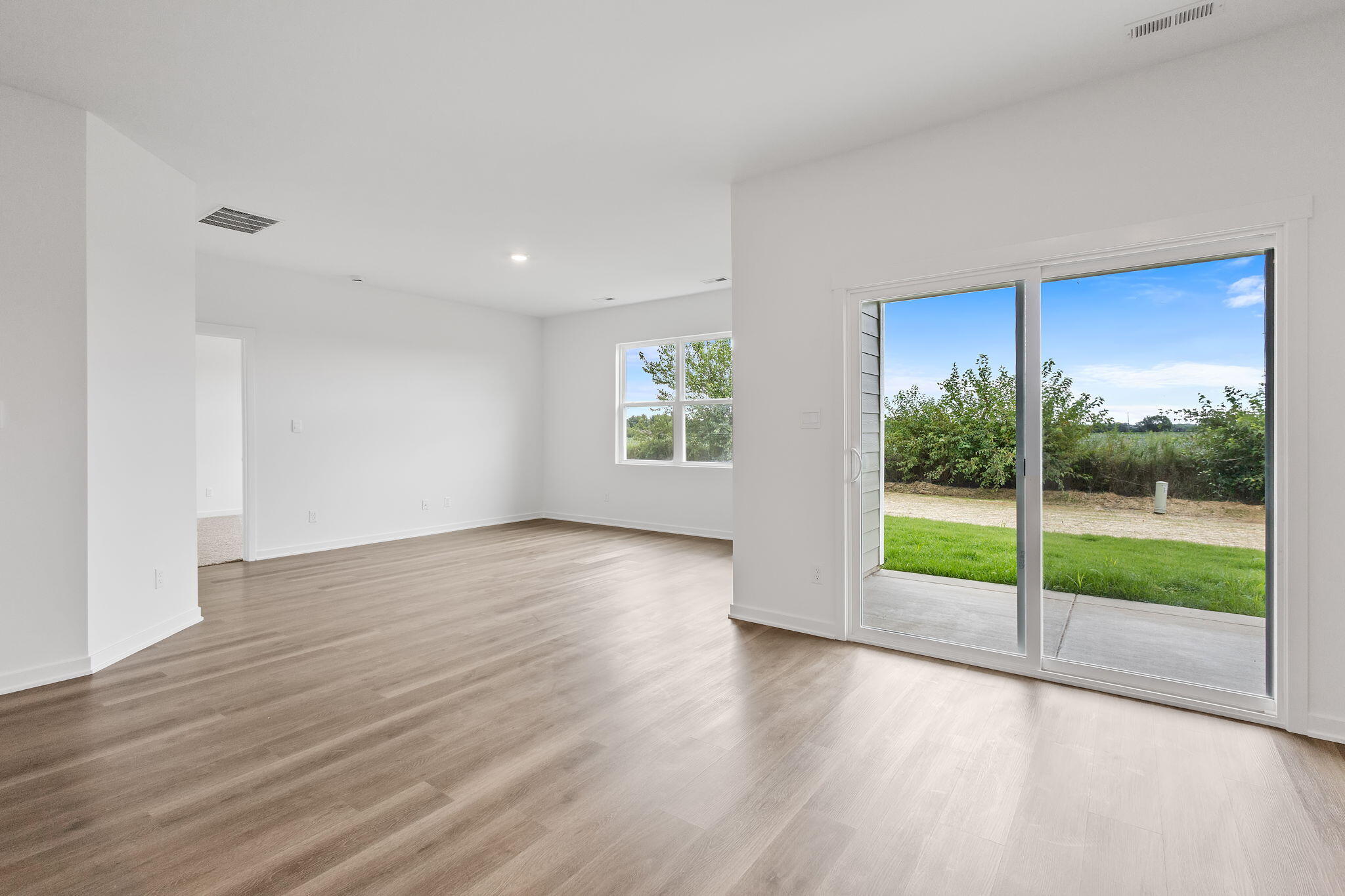 7293 West 107th Place Crown Point, IN 46307 - Photo 10 of 24 a view of an empty room with wooden floor and a window