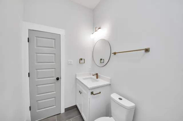 a bathroom with a toilet a sink and mirror