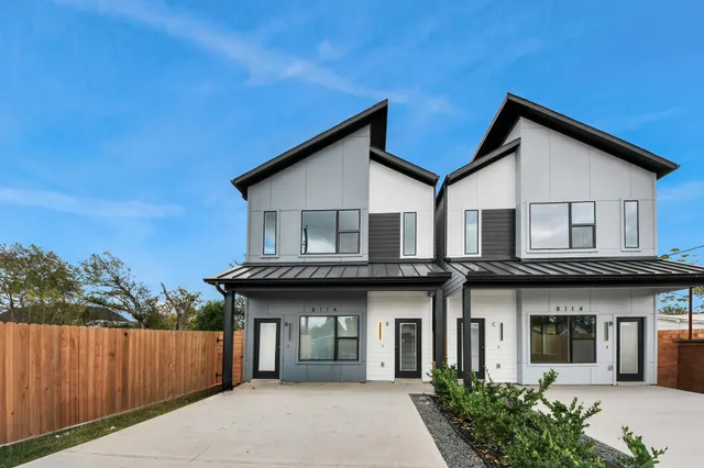 a front view of a house with a garden and plants