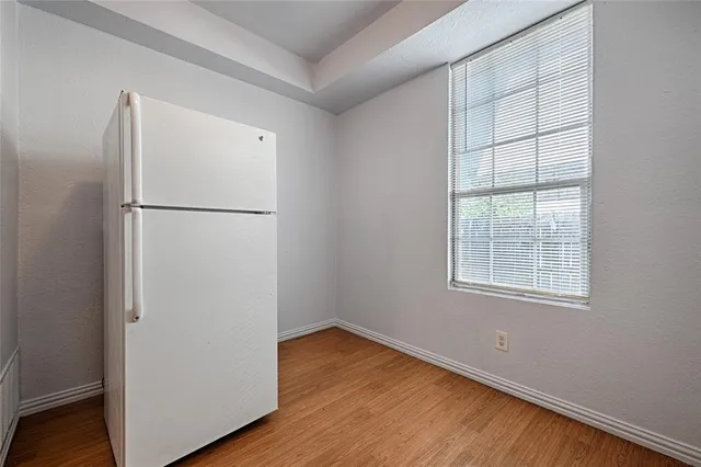 a view of a kitchen with wooden floor and window