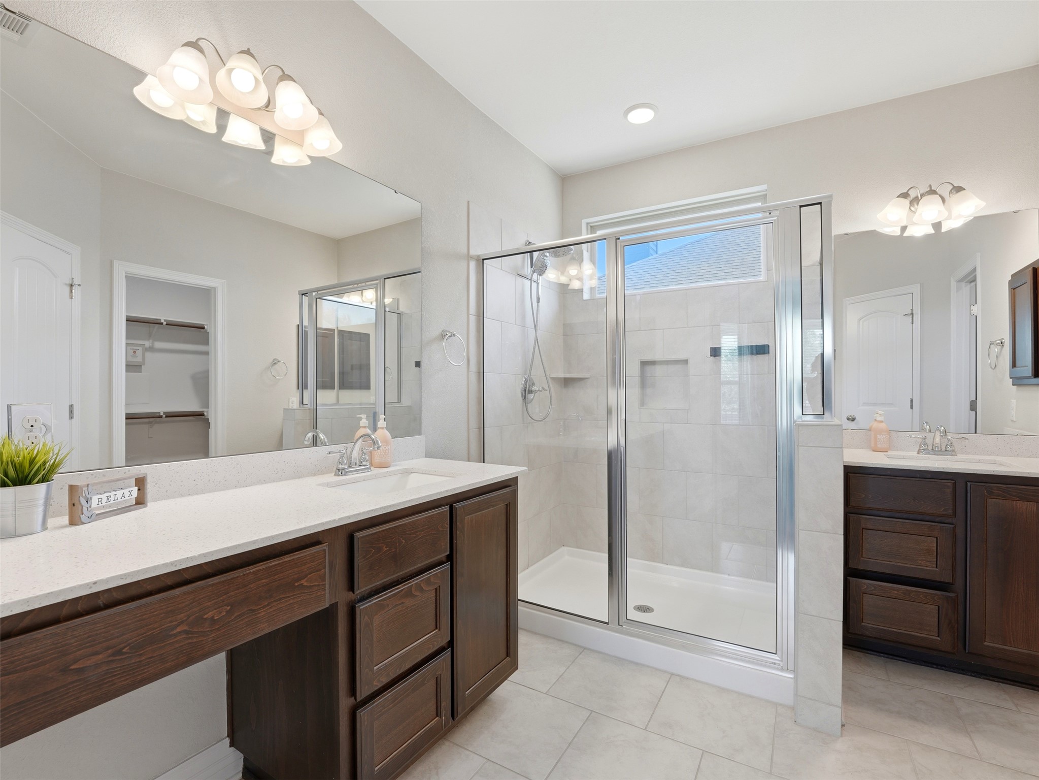 2132 Ringstaff Road Leander, TX 78641 - Photo 23 of 39 Dual vanities with ample counter space complement the spacious walk-in shower in this well-appointed bathroom.