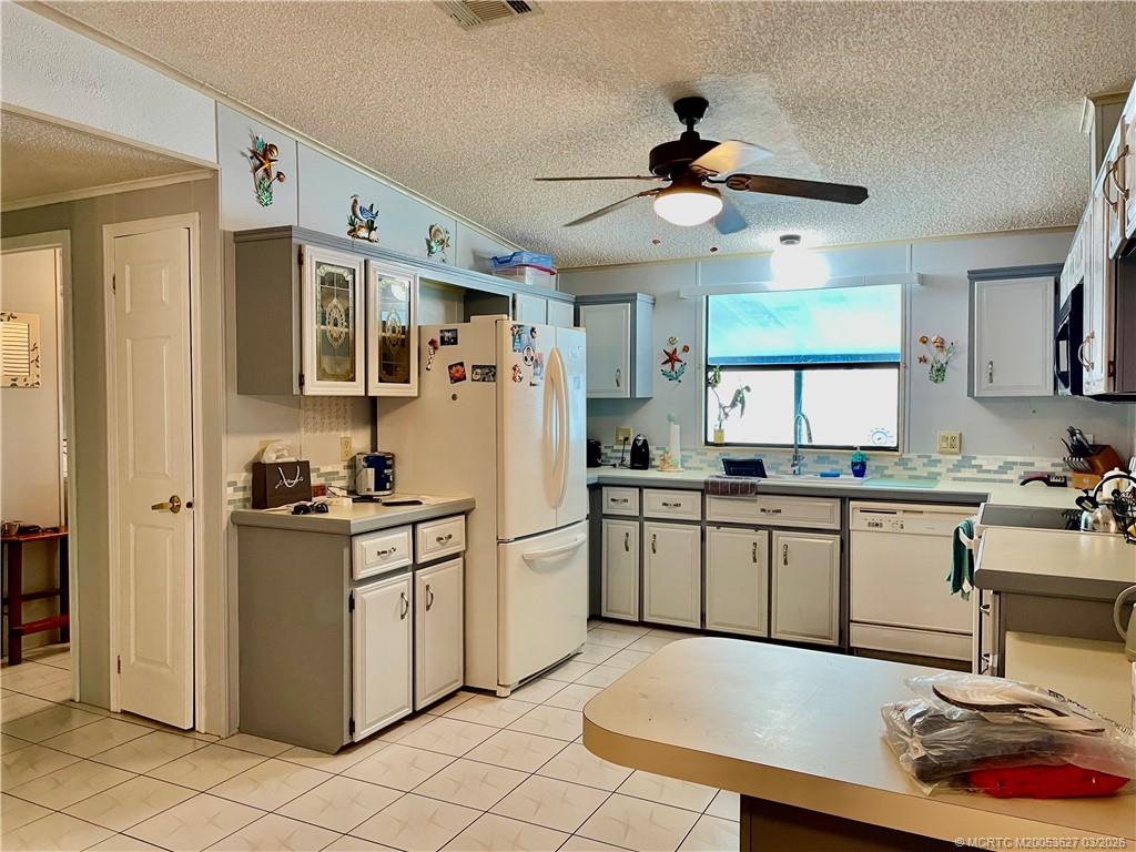14524 Southwest Rake Drive Indiantown, FL 34956 - Photo 15 of 24 a kitchen with stainless steel appliances granite countertop a stove a refrigerator a sink a dining table and chairs with wooden floor