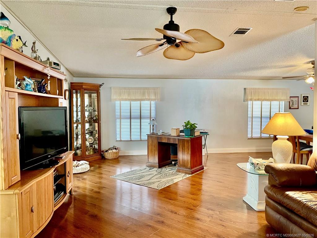 14524 Southwest Rake Drive Indiantown, FL 34956 - Photo 6 of 24 a living room with furniture flat screen tv and a fireplace