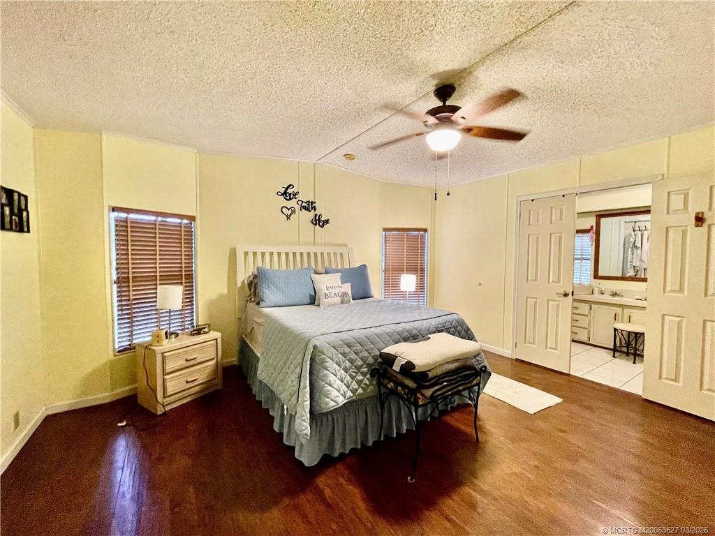 14524 Southwest Rake Drive Indiantown, FL 34956 - Photo 8 of 24 a bedroom with a bed and wooden floor