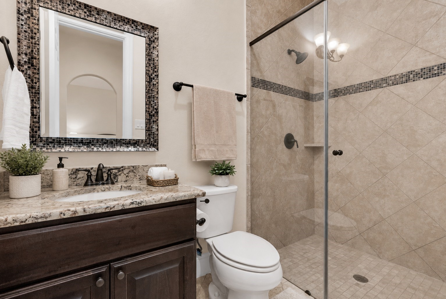 4022 Sabine Valley Trail Spring, TX 77386 - Photo 7 of 46 This bathroom features a modern design with a glass-enclosed shower, elegant tile work, and a granite-topped vanity. The dark wood cabinetry and framed mirror add a touch of sophistication, complemented by neutral tones and stylish fixtures.