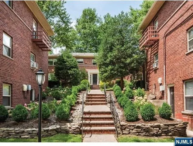 a front view of a residential apartment building with a yard