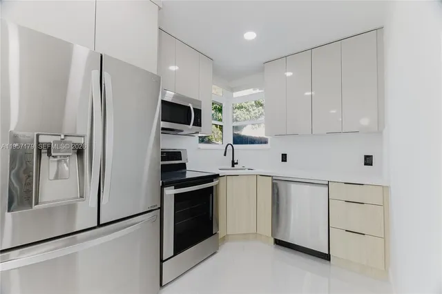 a kitchen with stainless steel appliances a refrigerator sink and microwave