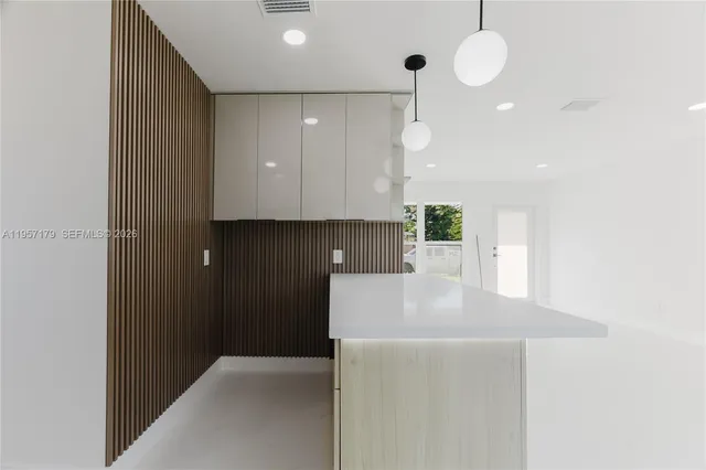 a kitchen with kitchen island a sink stainless steel appliances and cabinets