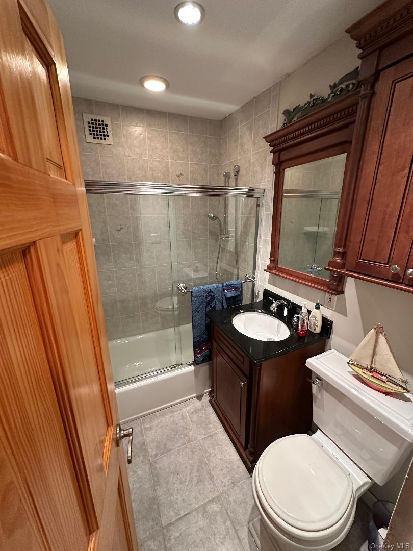 770 Shore Road, Unit 6EE Long Beach, NY 11561 - Photo 6 of 13 Full bath featuring combined bath / shower with glass door, vanity, and light tile patterned flooring