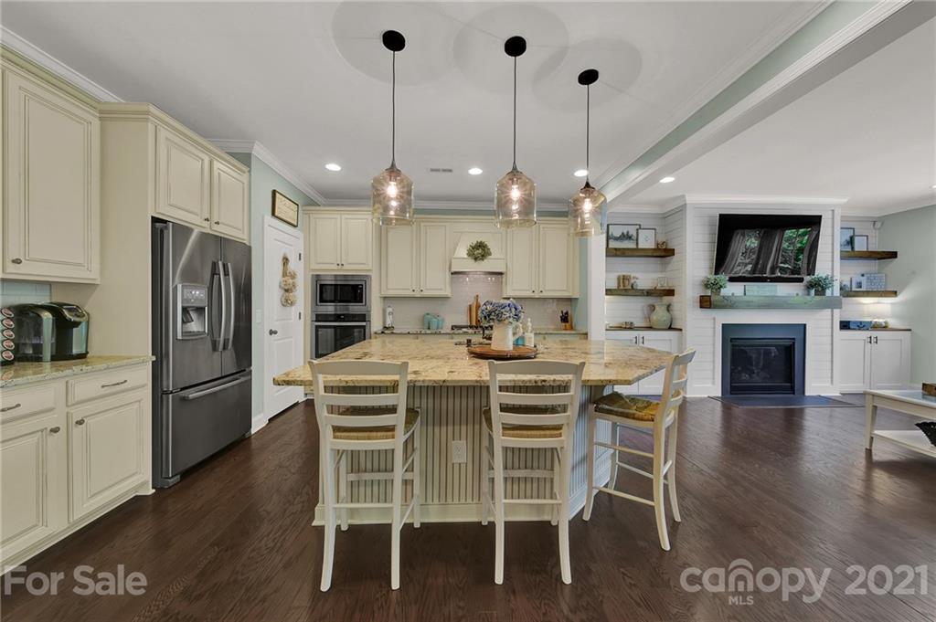 1033 Emory Lane Fort Mill, SC 29708 - Photo 11 of 48 a kitchen with stainless steel appliances kitchen island granite countertop a stove a refrigerator a oven a fireplace with a dining table and chairs