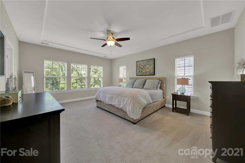 1033 Emory Lane Fort Mill, SC 29708 - Photo 32 of 48 a bedroom with a large bed and a chandelier