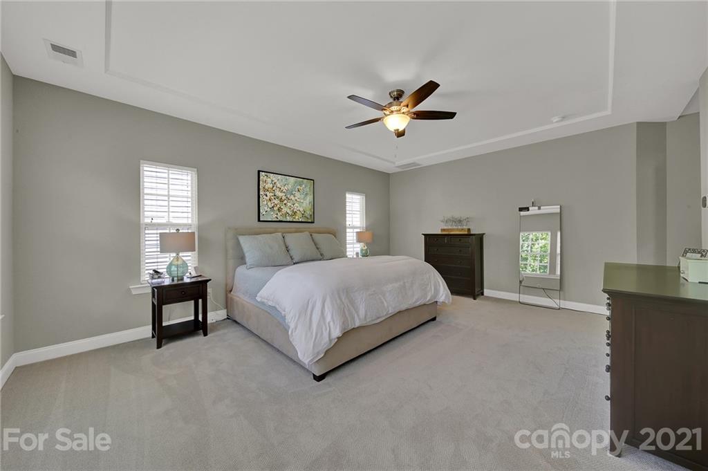 1033 Emory Lane Fort Mill, SC 29708 - Photo 33 of 48 a spacious bedroom with a bed and a chandelier