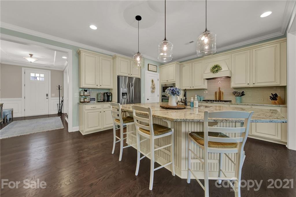 1033 Emory Lane Fort Mill, SC 29708 - Photo 9 of 48 a kitchen with stainless steel appliances kitchen island granite countertop a stove a refrigerator a oven a sink with a dining table and chairs