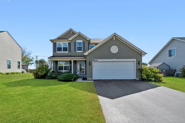 a front view of a house with a yard and garage