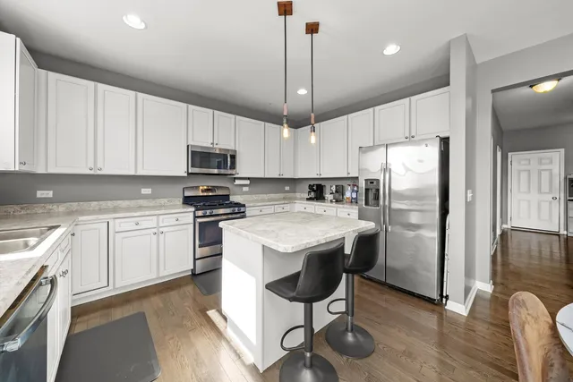 a kitchen with stainless steel appliances granite countertop a stove microwave sink and refrigerator