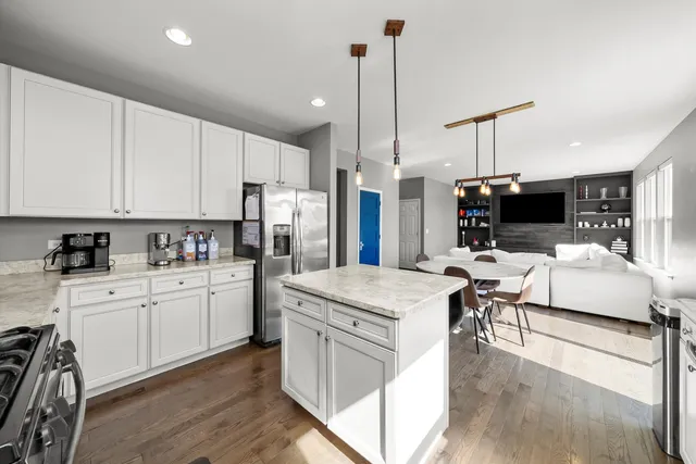 a kitchen with granite countertop white cabinets sink and stainless steel appliances
