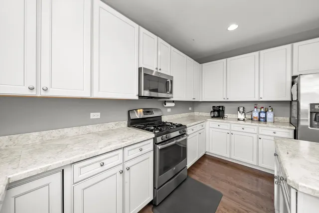 a kitchen with stainless steel appliances granite countertop a stove a sink and a microwave