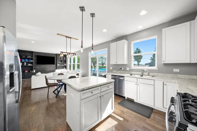 a kitchen with stainless steel appliances granite countertop a sink a stove and a microwave