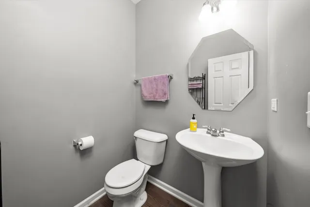 a view of a livingroom with wooden floor and stairs