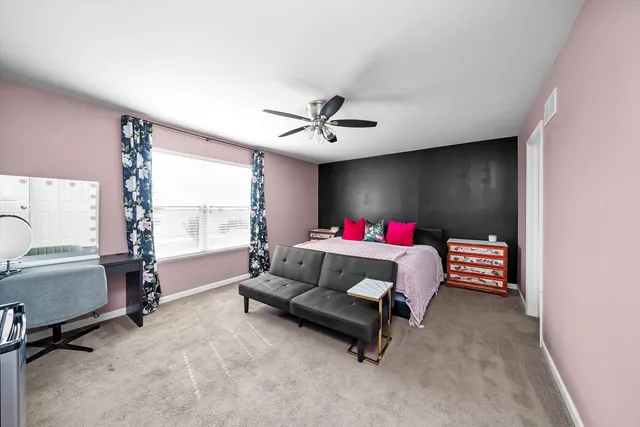 a bedroom with a bed and ceiling fan