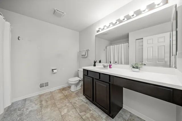 a bedroom with a bed dresser and flat screen tv