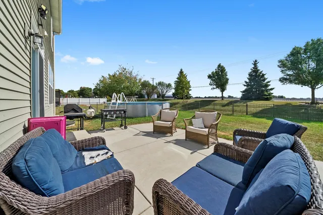 a view of a patio with couches and a table and chairs with wooden fence