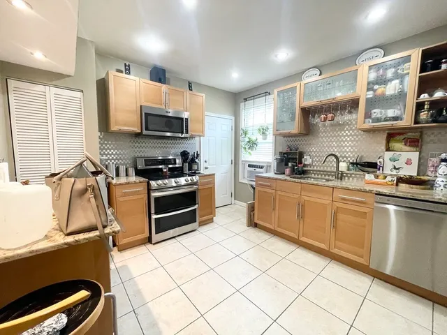 a kitchen with stainless steel appliances a stove a sink a microwave a refrigerator and cabinets