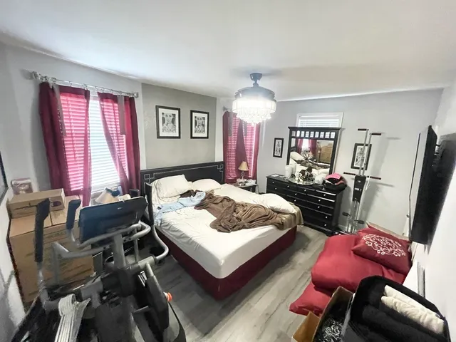 a bedroom with a bed window and a chair