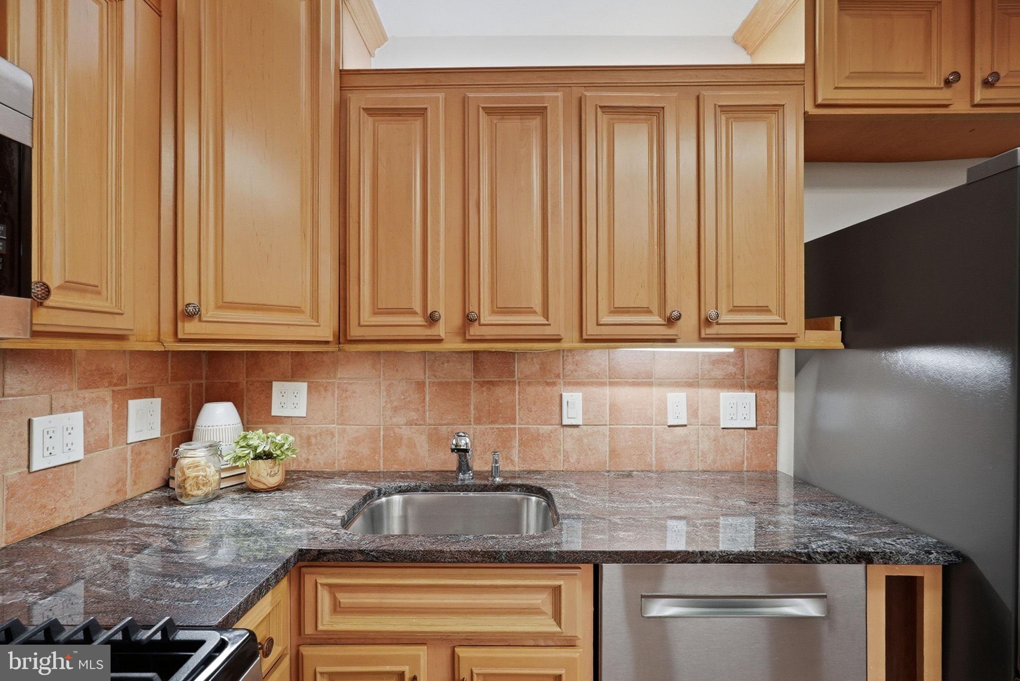 3001 Veazey Street Northwest, Unit 116 Washington, DC 20008 - Photo 11 of 40 a kitchen with granite countertop stainless steel appliances granite countertop white cabinets sink and dishwasher